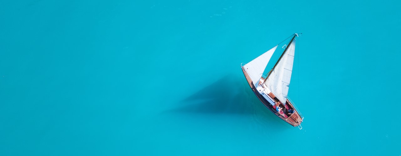 Sailing boat on the sea shot from above